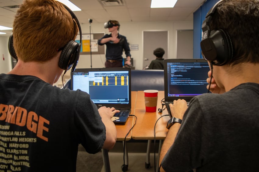 students using laptops with headphones