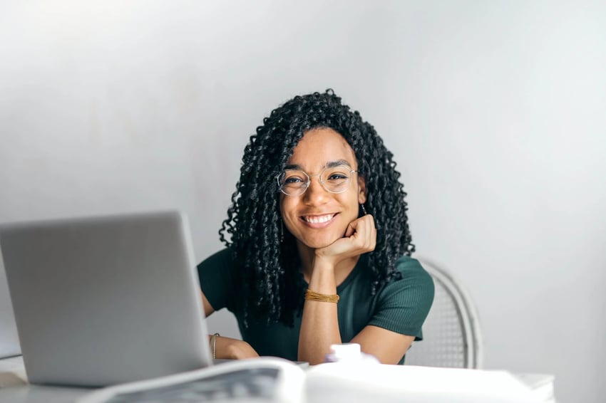 student on laptop smiling at camera