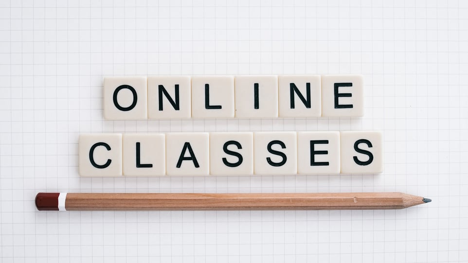 scrabble tiles spelling "online classes" with a pencil below