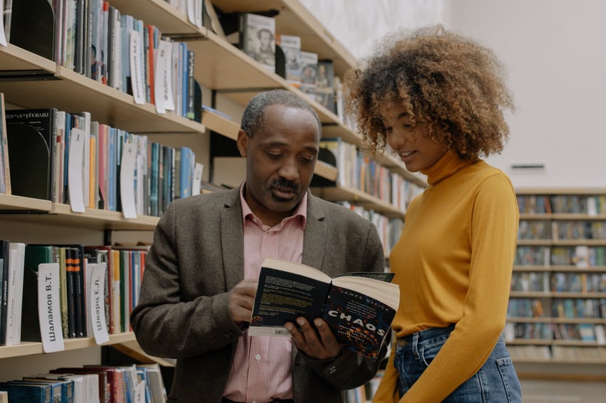 professor and student looking at a book together