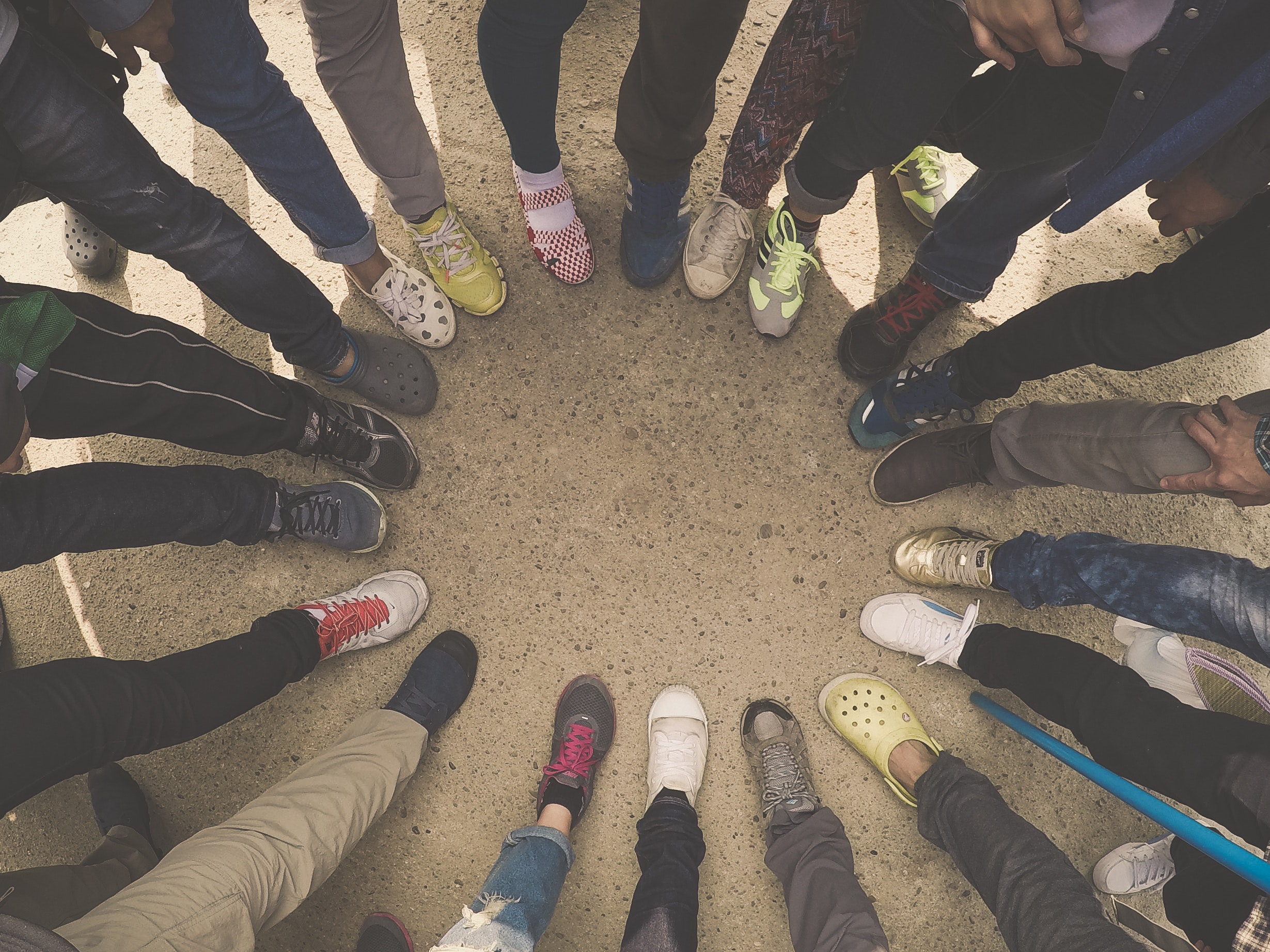 a group of people stand in a circle, lining up their feet