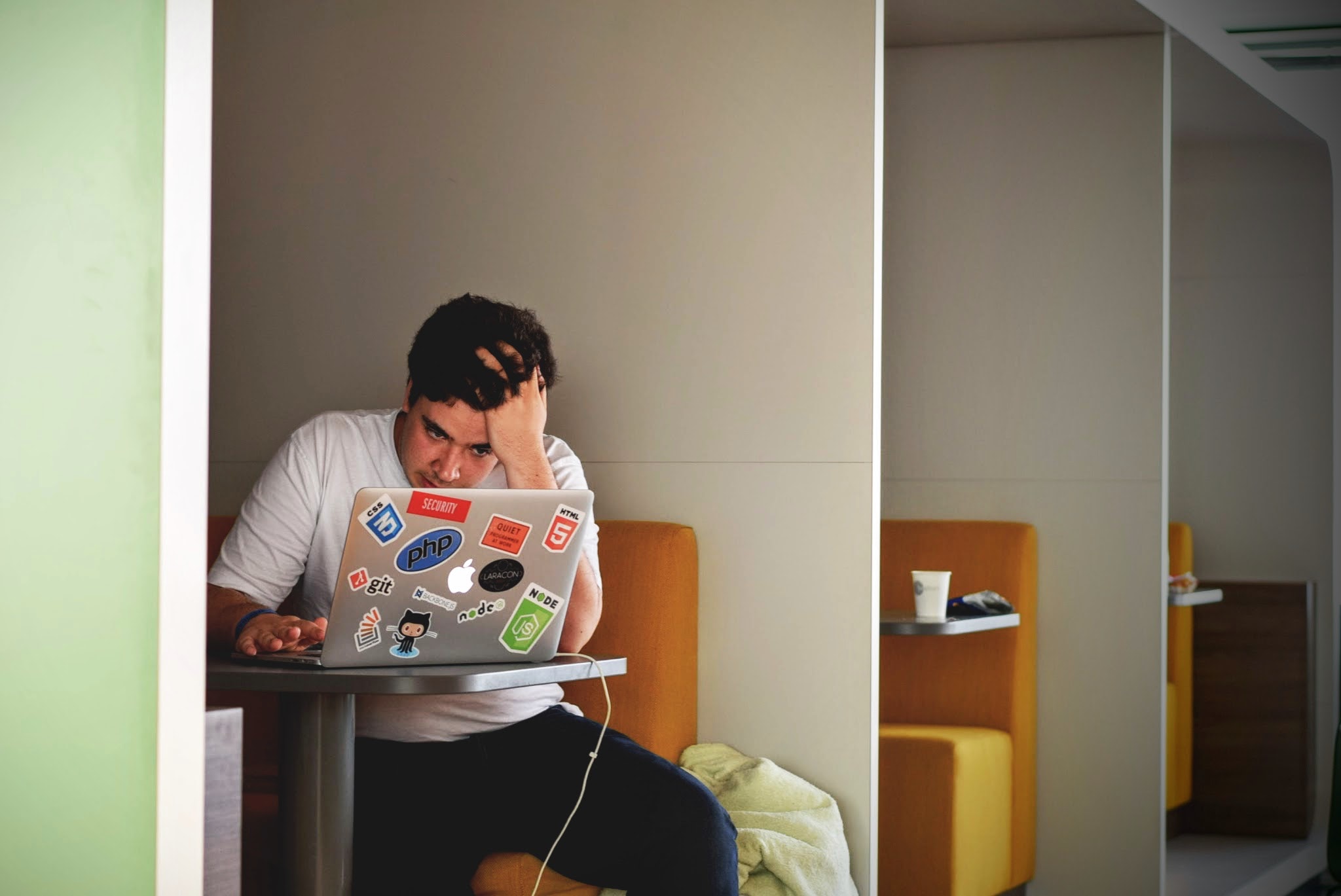 a student works on his laptop, looking stressed