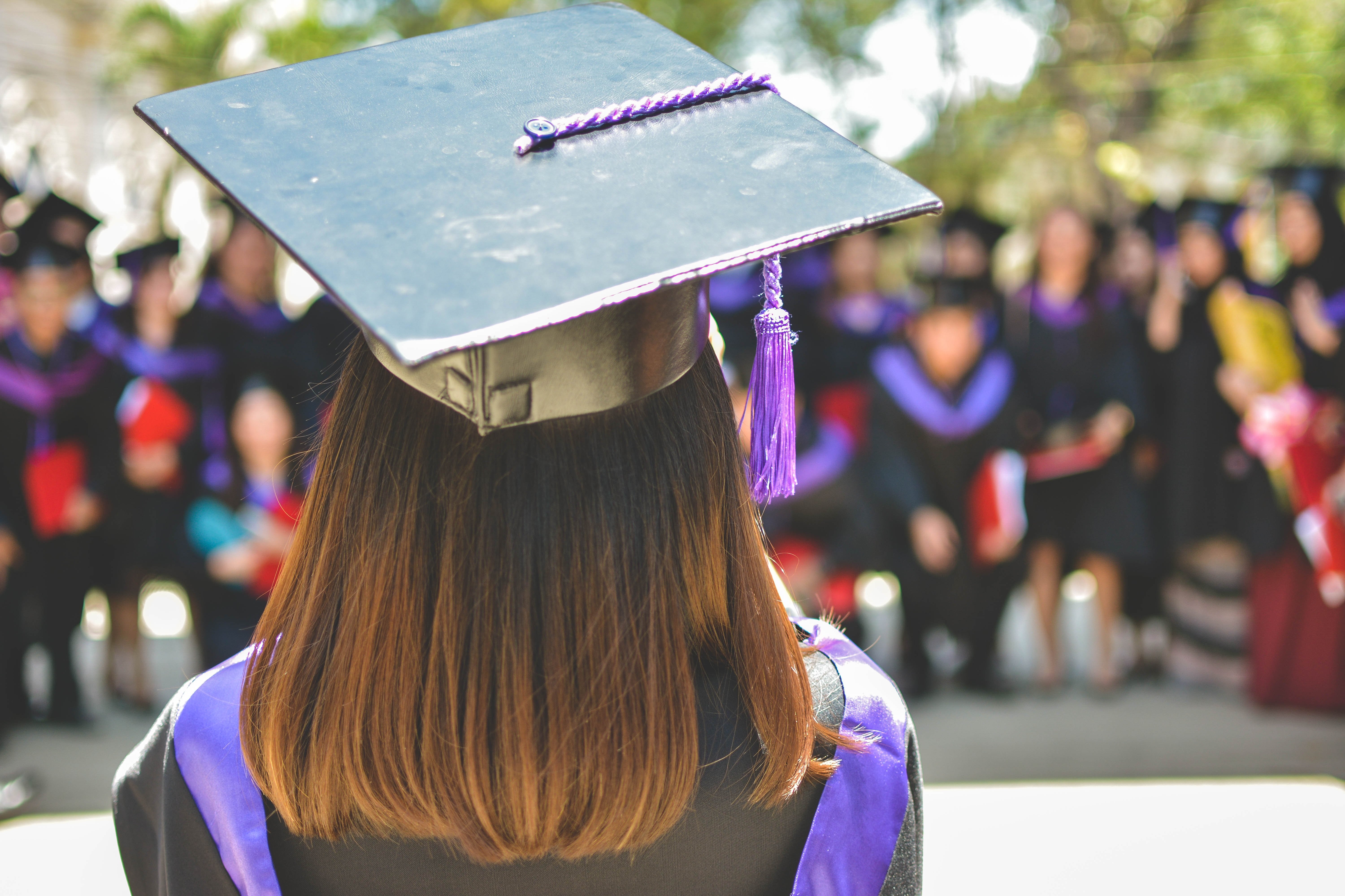 a student is shown wearing a graduation gown and cap