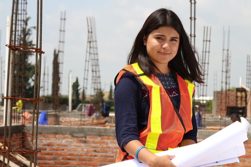 a woman poses on a job site