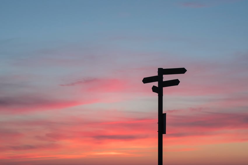 silhouette of road sign against blue and pink sky