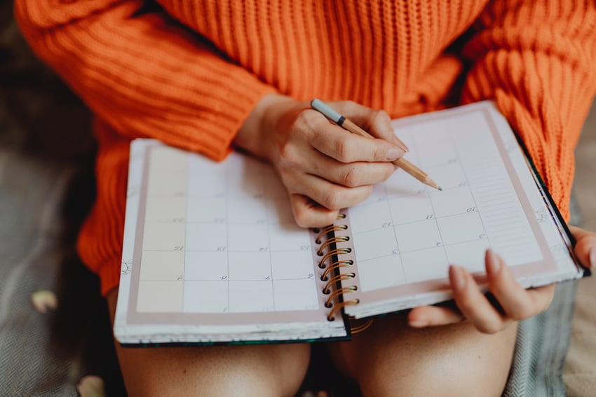 person writing on a calendar