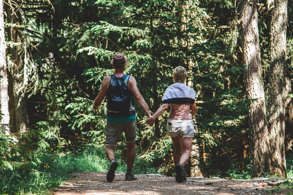 couple holding hands in a forest