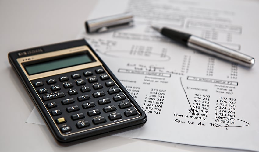 calculator and expense sheet on table