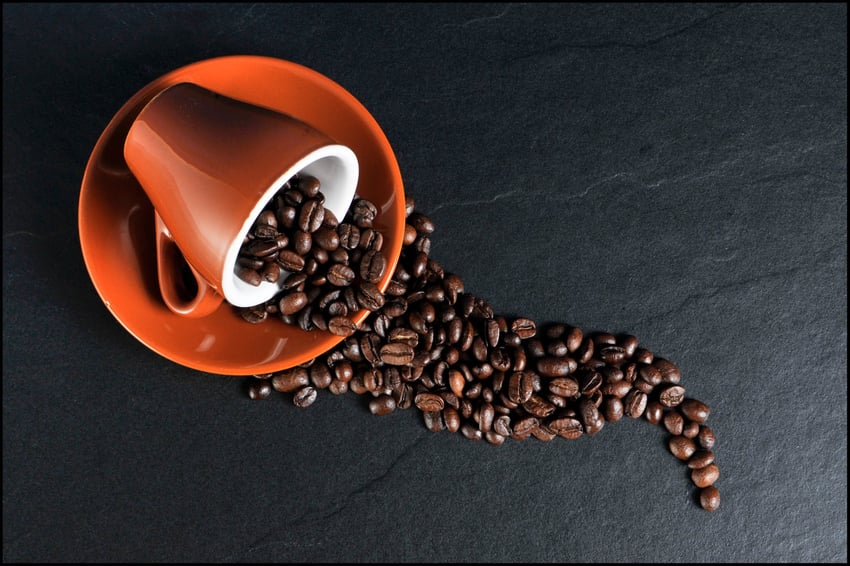 mug with coffee beans spilling out