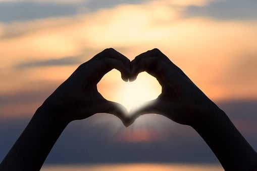 Silhouette of two hands making a heart