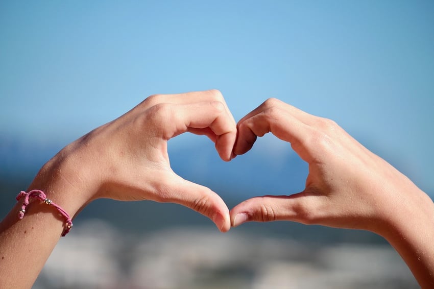 Hands put together in the shape of a heart.