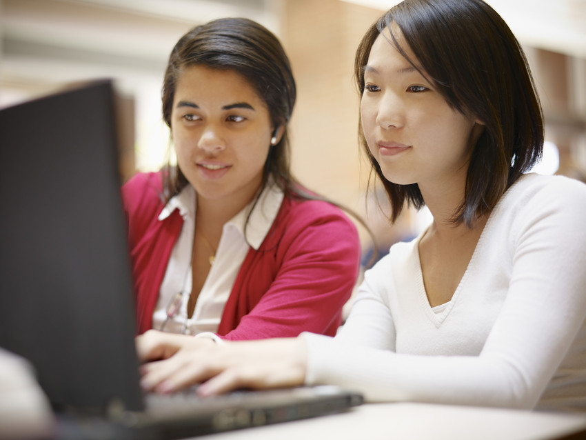 Two women working at a computer 