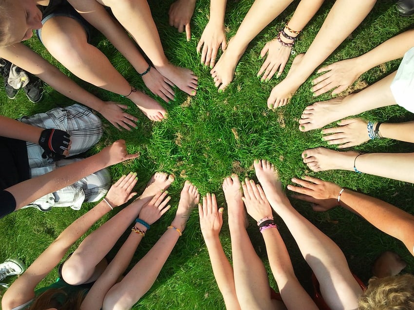 a group of people with their hands in a circle