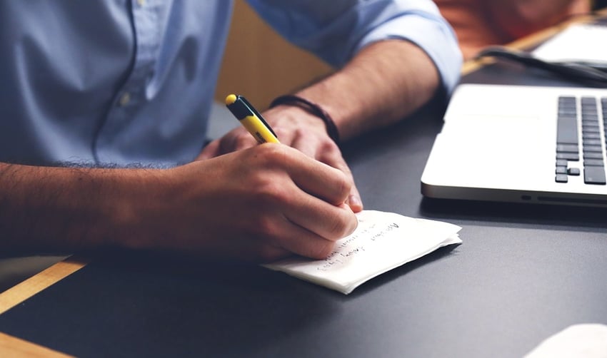 Person taking notes on a piece of paper