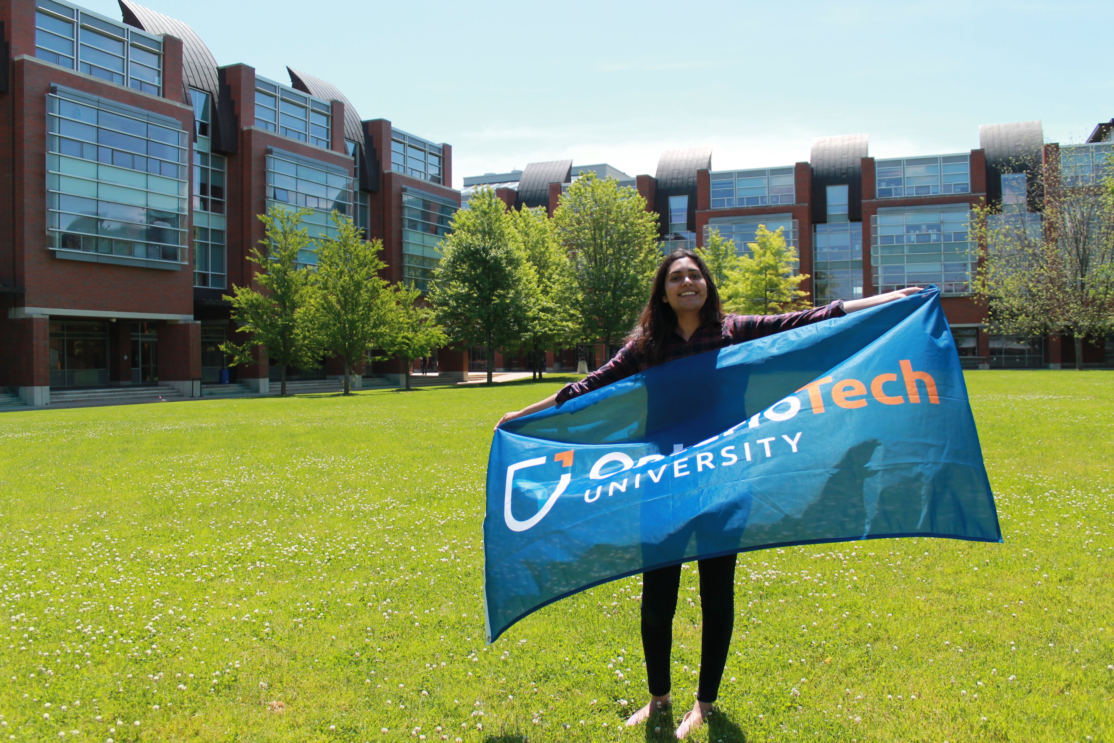 Student holding an Ontario Tech flag 