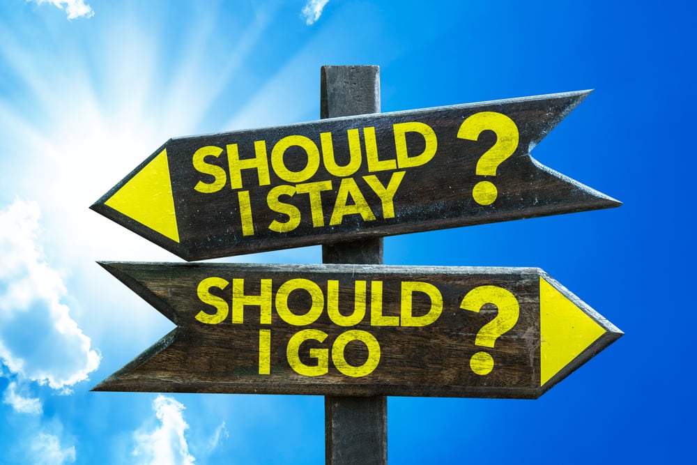 Should I Stay? Should I Go? signpost with sky background
