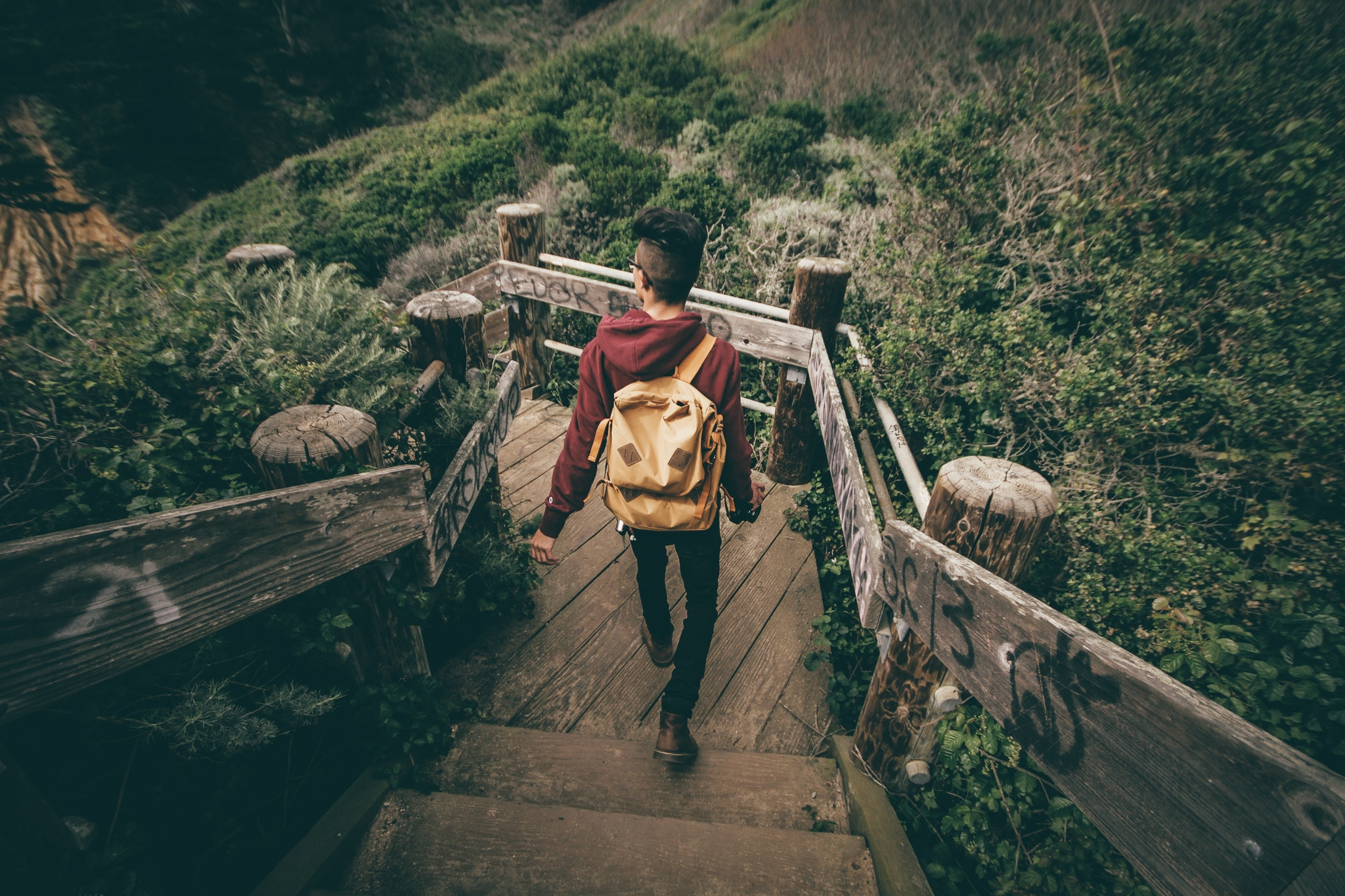 Student with a backpack walking down a stair case outdoors