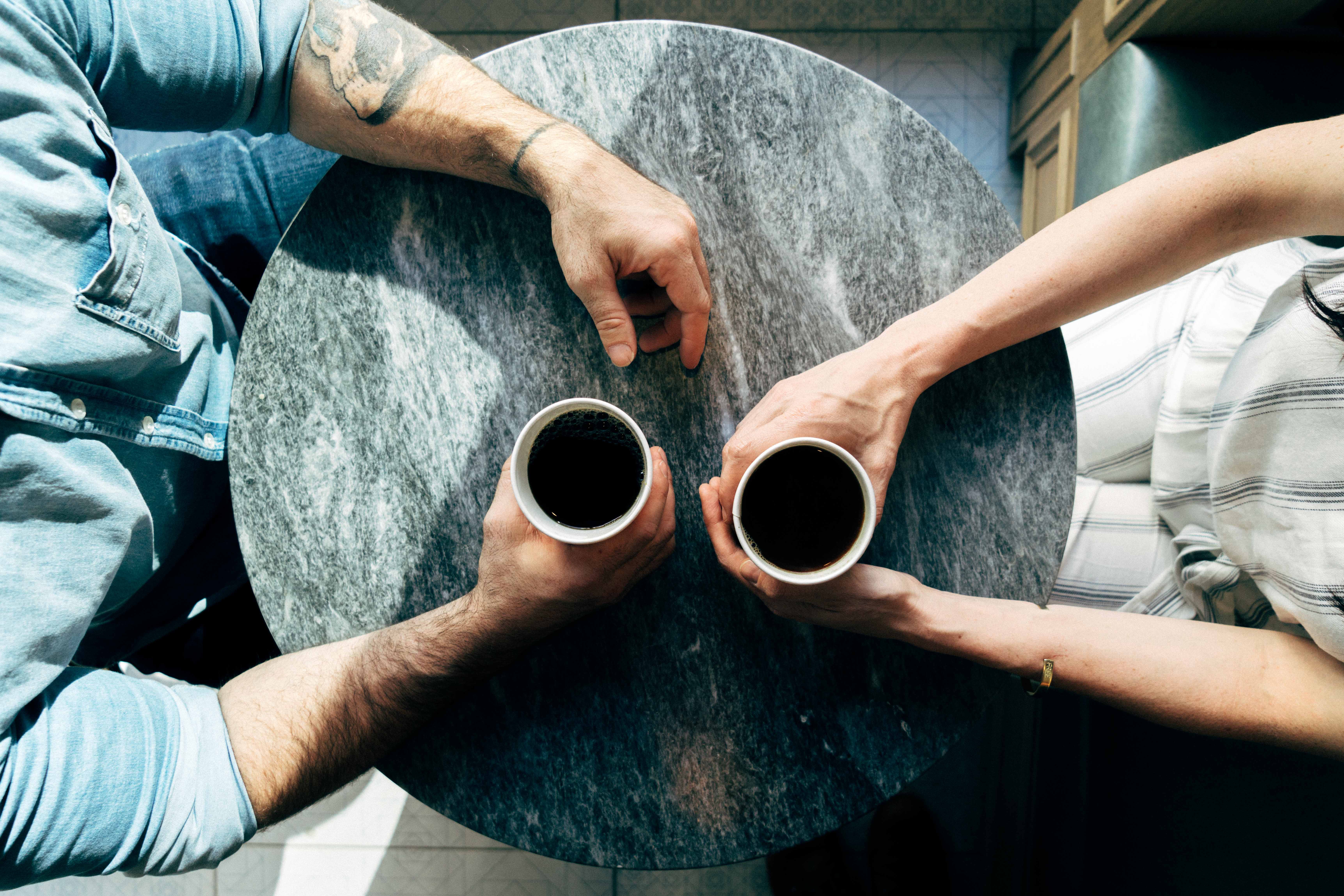Two people drinking coffee at a table